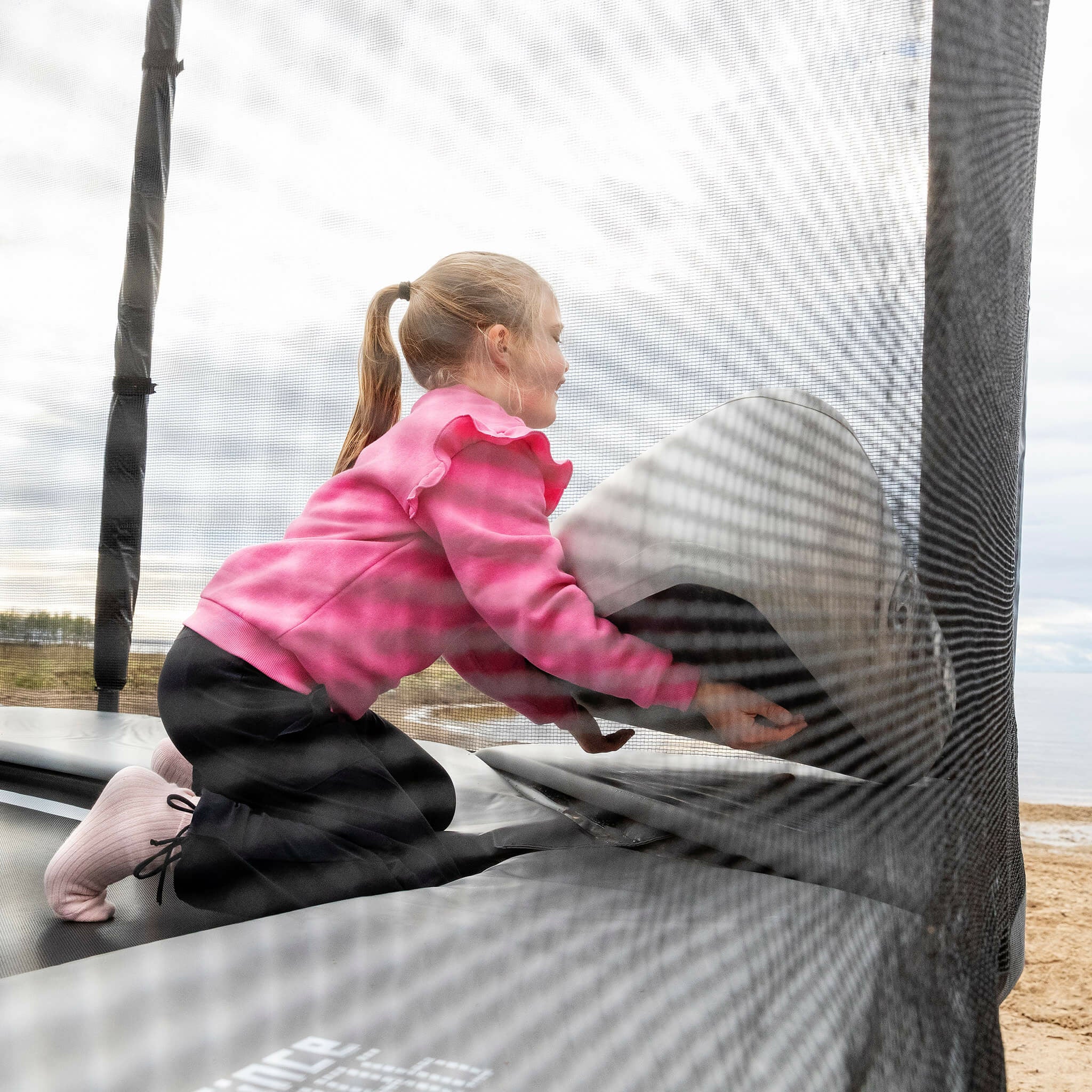 Flickan sätter upp det uppblåsbara triangelblocket på Acon X-trampolinen.