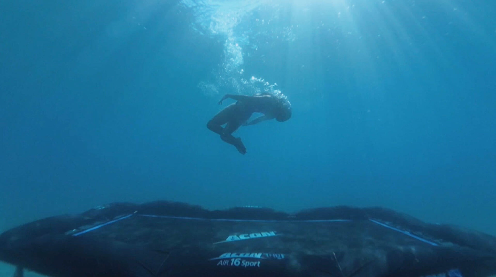 En person som hoppar på en studsmatta under vatten 