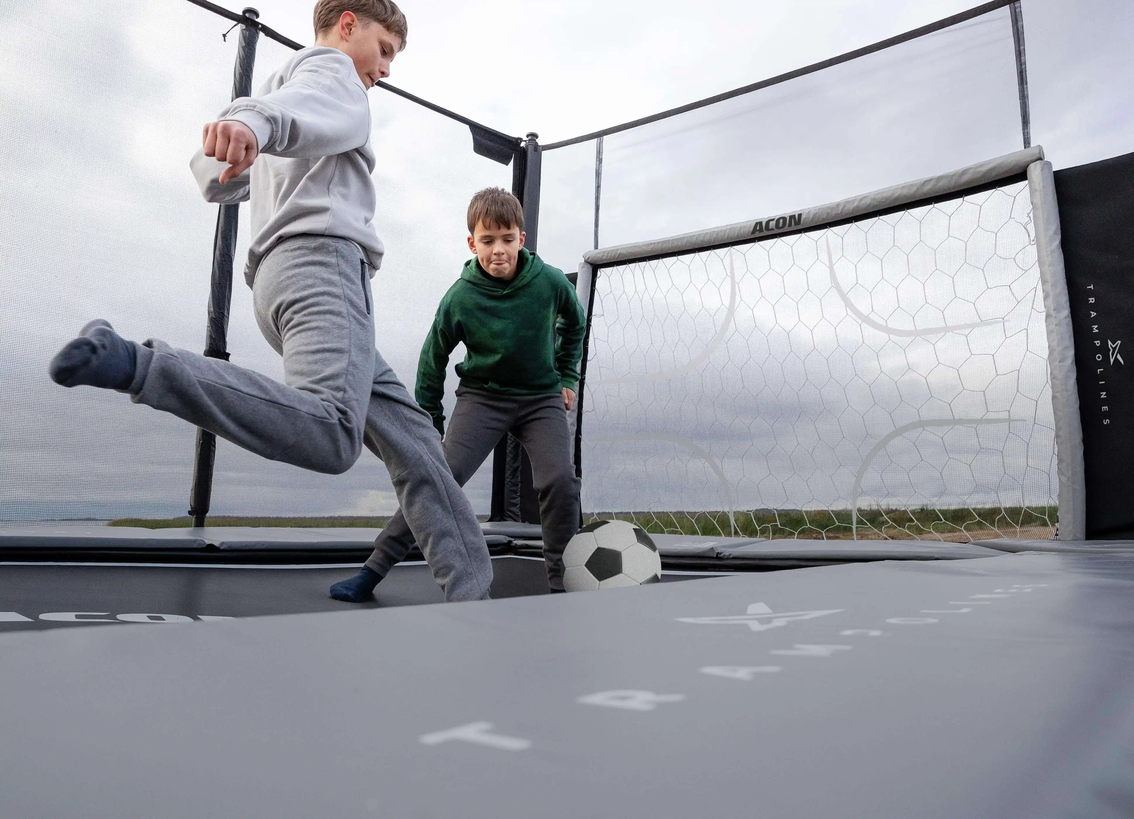Två pojkar spelar trampolinfotboll på Acon X Trampoline.
